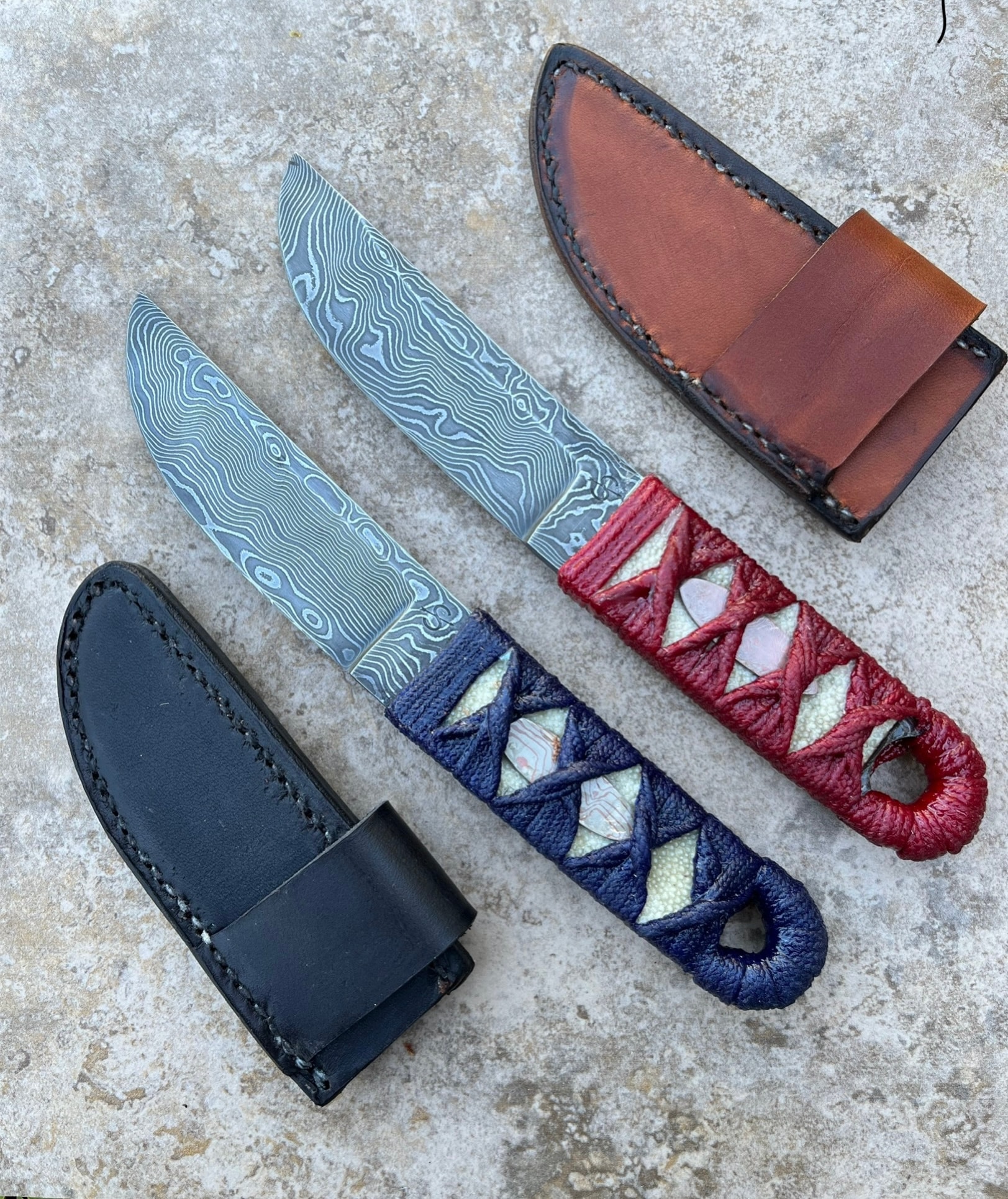 Pair of Damascus knives with wrapped handles and leather sheaths